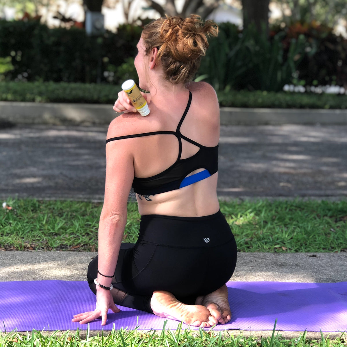 Relief Plus Muscle Oil being applied to a woman's back after a yoga session