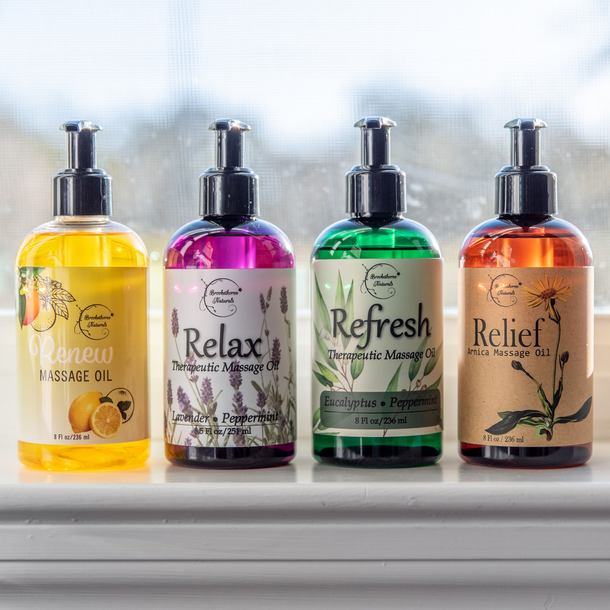 Mega Massage Oil Bundle on window sill; Renew, Relax, Refresh, and Relief Massage Oils