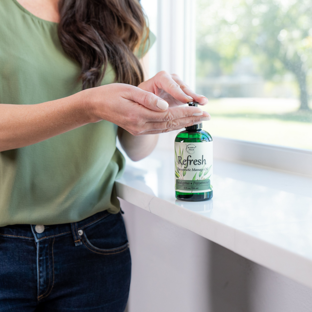 Refresh Massage Oil being pumped into a woman's hands