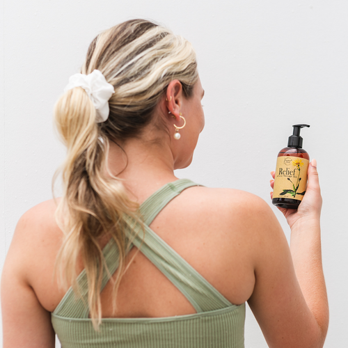 Woman holding Relief Arnica Massage Oil