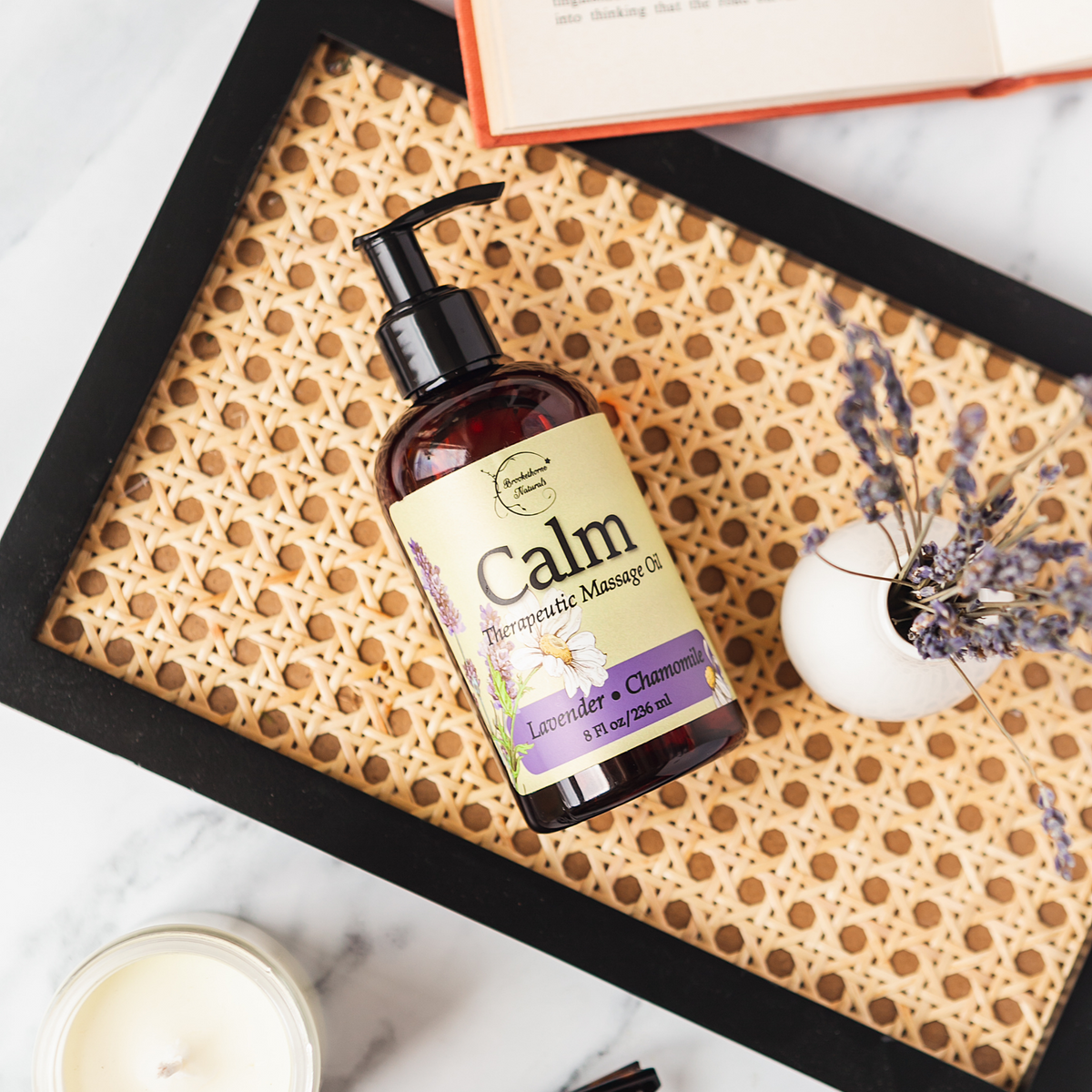 Calm Therapeutic Massage Oil on wicker tray with lavender flowers