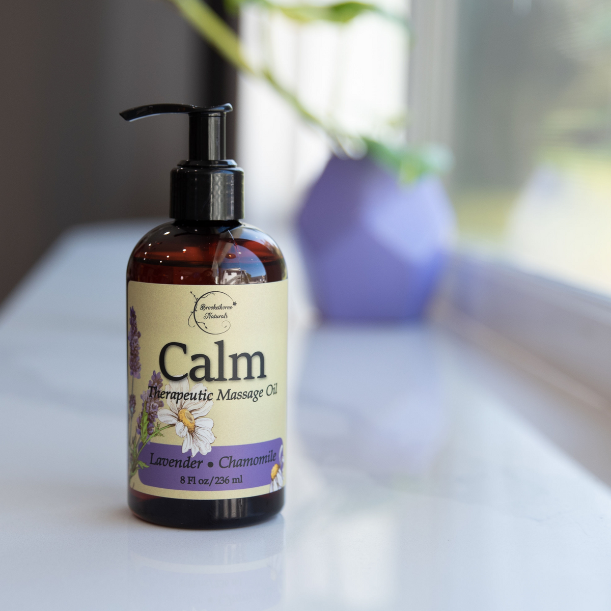 Calm Therapeutic Massage Oil on a window sill. 