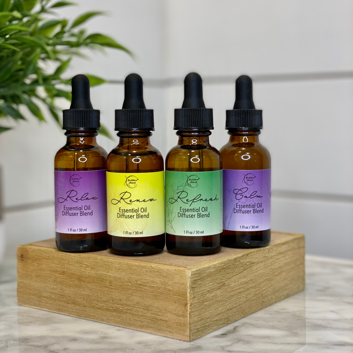 Relax, Renew, Refresh, and Calm Essential Oil Diffuser Blends sitting on a wooden block