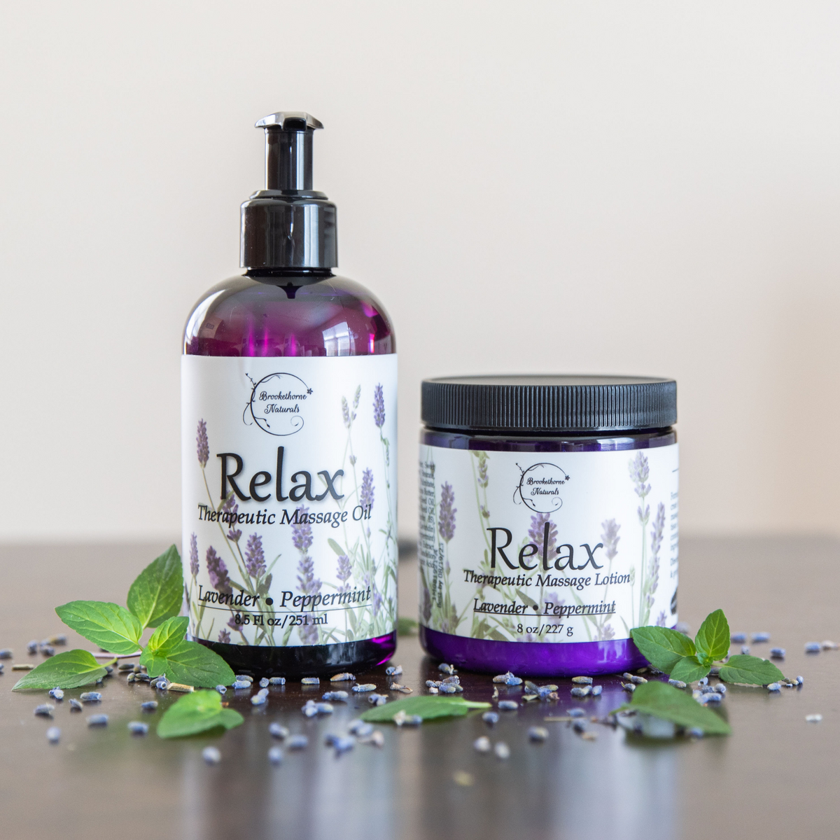 Just Relax Bundle, Relax Therapeutic Massage Oil and Relax Therapeutic Massage Lotion surrounded by lavender seeds.