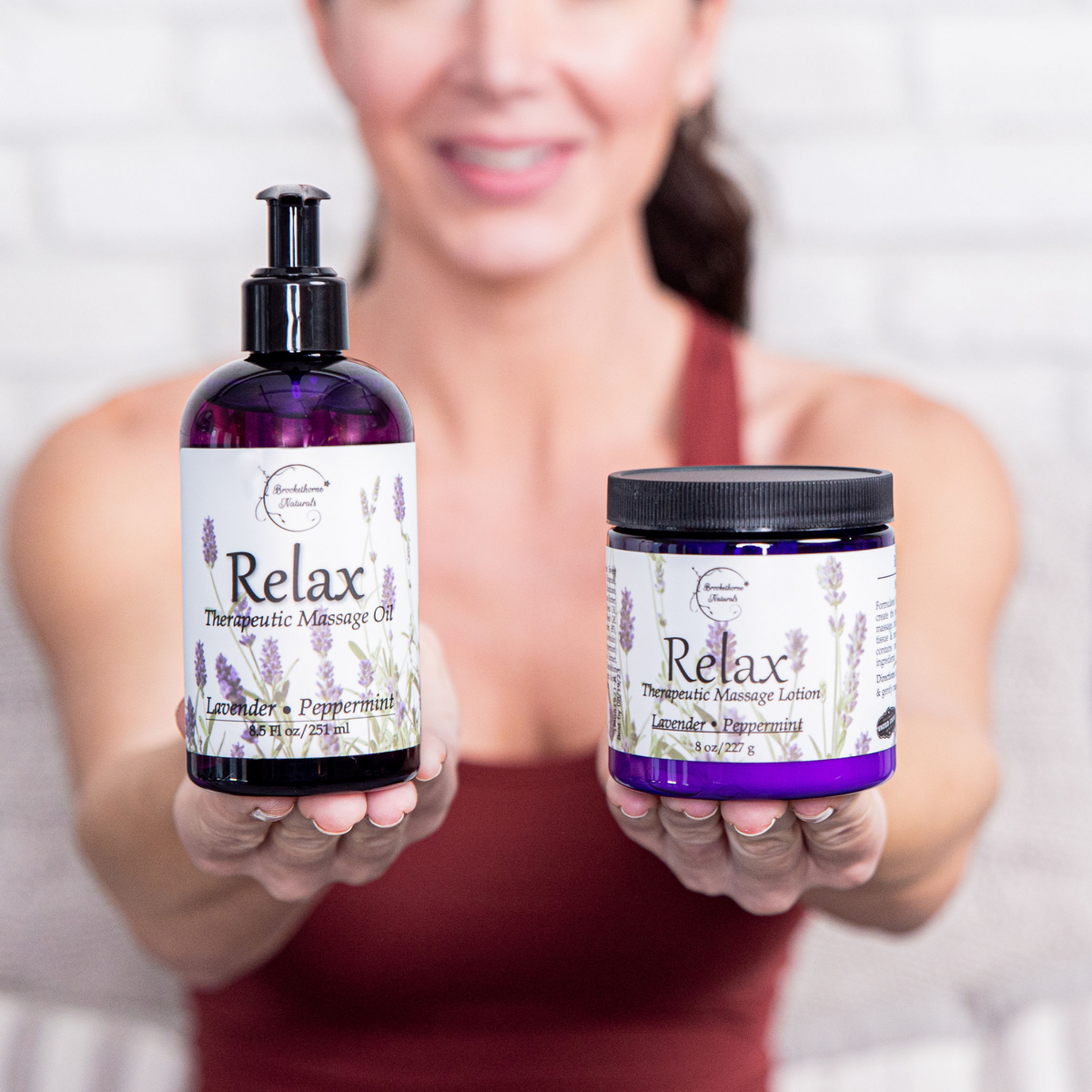 Just Relax Bundle, Relax Therapeutic Massage Oil and Relax Therapeutic Massage Lotion being held by woman.