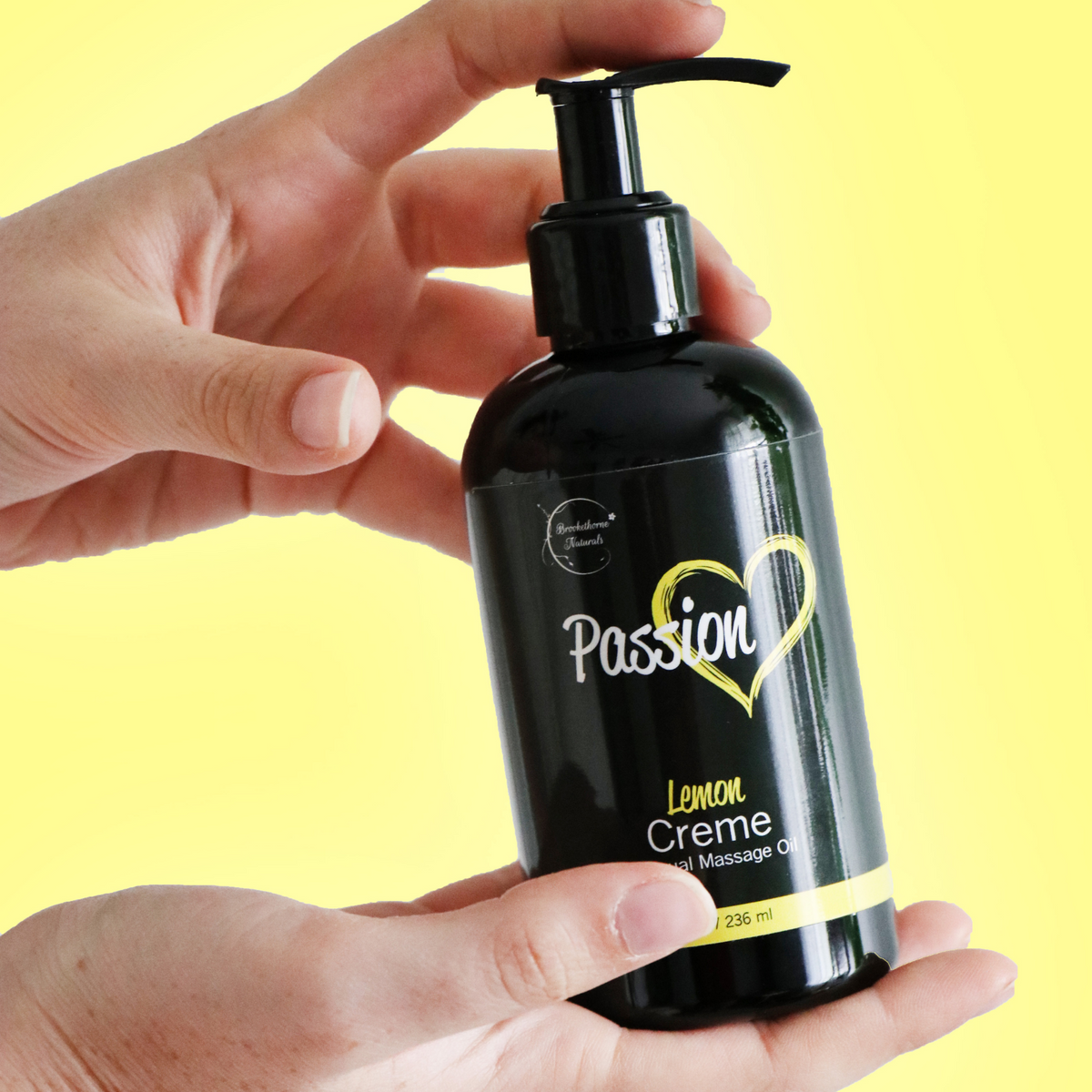 Passion Lemon Creme Bottle being displayed in a womans hands