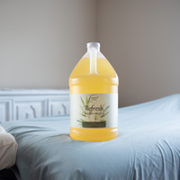 Refresh Therapeutic Massage Oil 1 Gallon jug sitting on a massage table